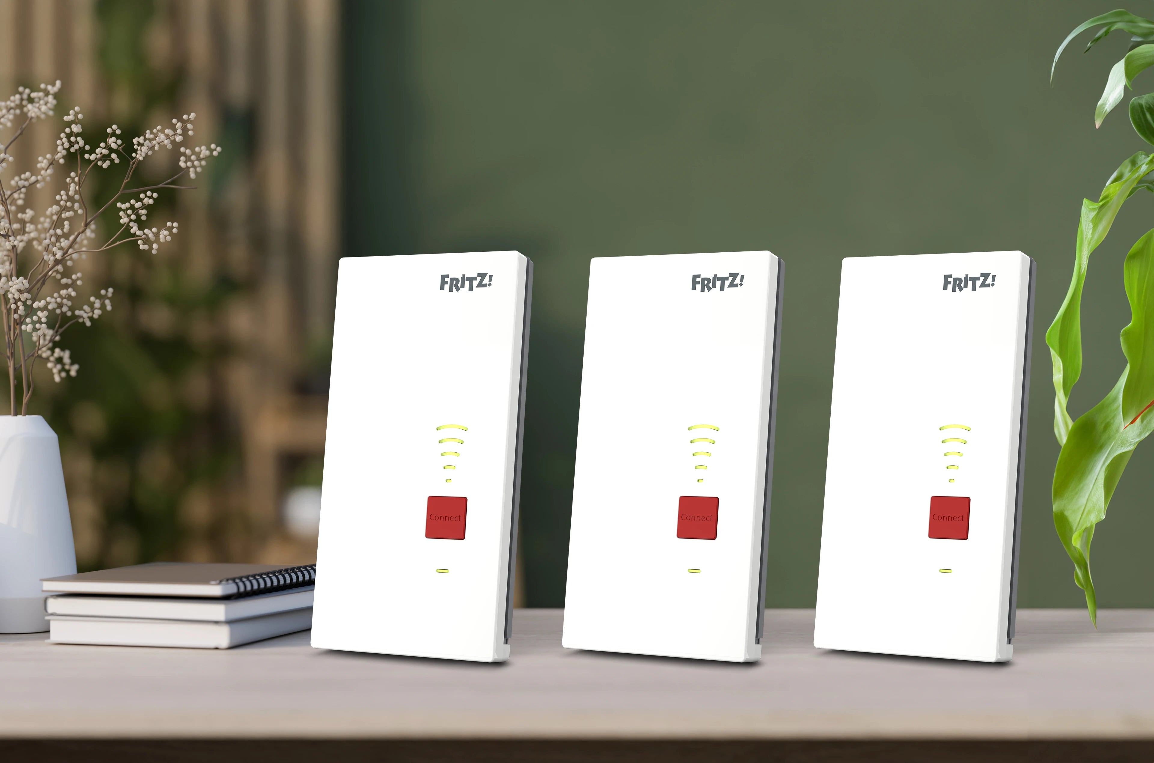 Drei FRITZ!Repeater auf einem Tisch, optimiert für WLAN-Signalverstärkung und Netzwerkerweiterung.